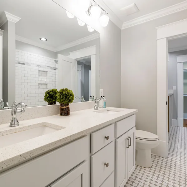 Bathroom vanity with a quartz top, undermount sink, and mosaic tile flooring in a finished Findlay bathroom