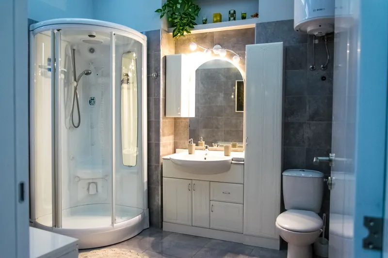 Corner shower enclosure beside a wall-hung vanity in a compact bathroom