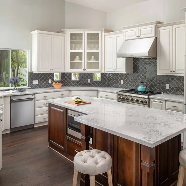 Open kitchen with a dark wood island and seating, looking through to the adjoining room