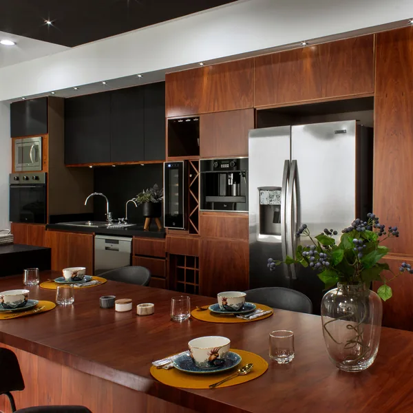 Open kitchen with a dark wood island and seating, looking through to the adjoining room
